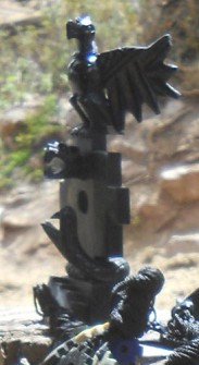 Kunsthandwerkwerkstatt in
                    Cusco Sacsayhuamn: Schwarze Figuren 04, ein Adler
                    auf einem Mutter-Erde-Kreuz