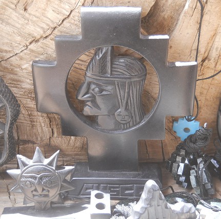 Handicraft workshop in
                    Cusco Sacsayhuamn: cross of Mother Earth 02 in
                    black with an Inca head in it's center - zoom