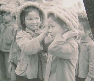 Kinder im Vietnamkrieg:
                                      Sch�lerinnen korrigieren sich in
                                      der Schule die Strohh�te