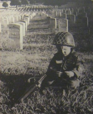 Ein Kind vor einem
                              Friedhof mit einem Gedicht