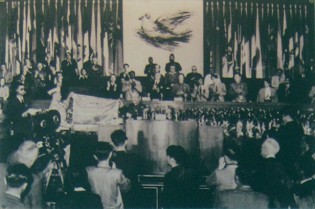 Die
                              Vietnam-Friedensfahne von 1953: Der
                              vietnamesische Kriegsheld Nguy�n Quoc Tri
                              repr�sentierte eine vietnamesische Gruppe,
                              die 1953 an der Weltfriedenskonferenz die
                              Fahne "Sch�tzt den Weltfrieden"
                              �berreicht bekam.