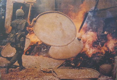 My-Lai-Massaker: Ein
                                      NATO-Soldat legt die Reisf�cher
                                      ins Feuer: Ein Soldat f�chert das
                                      Feuer mit den K�rben an, die zum
                                      Reistrocknen und Wurzeltrocknen
                                      verwendet werden.